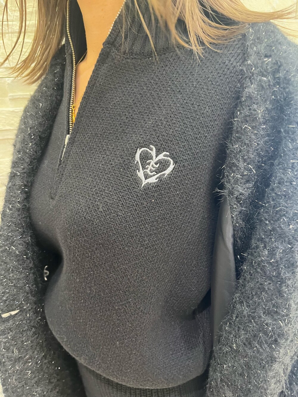 ブラック系のチェスターコート、ブラック系のつなぎ/オールインワン、ブラック系のブーツを着用したレディースの冬コーディネートの7枚目の写真