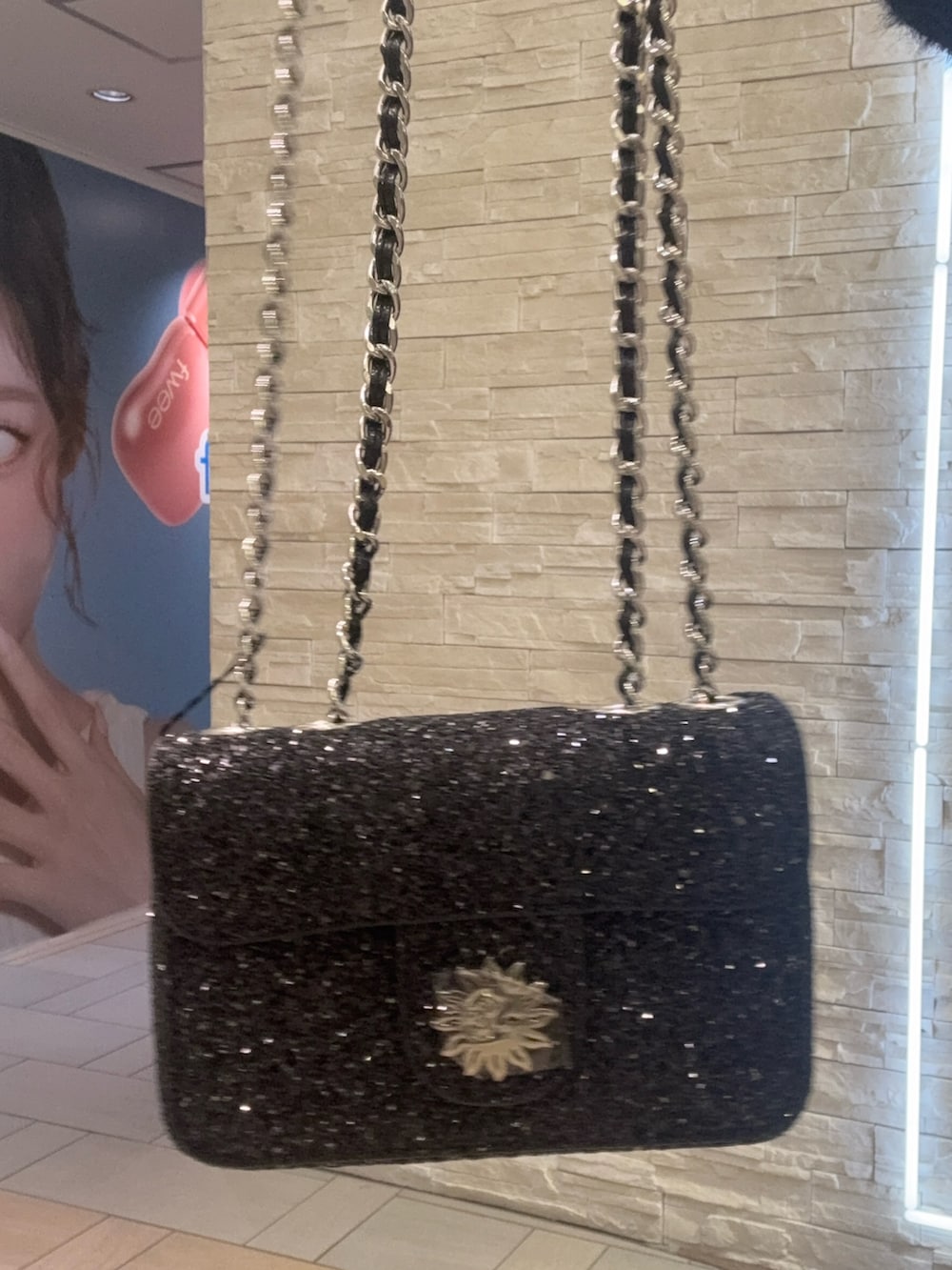 ブラック系のニット/セーター、ブルー系のデニムパンツ、ブラック系のショルダーバッグを着用したレディースの冬コーディネートの6枚目の写真