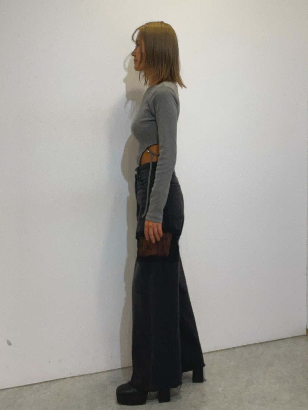 グレー系のTシャツ/カットソー、ブラック系のデニムパンツ、ブラック系のブーツを着用したレディースの秋コーディネートの2枚目の写真