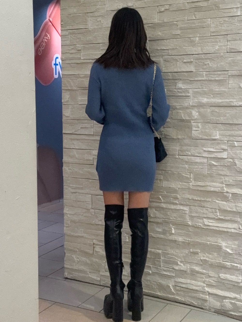 ブルー系のワンピース、ブラック系のショルダーバッグ、ブラック系のブーツを着用したレディースの冬コーディネートの3枚目の写真