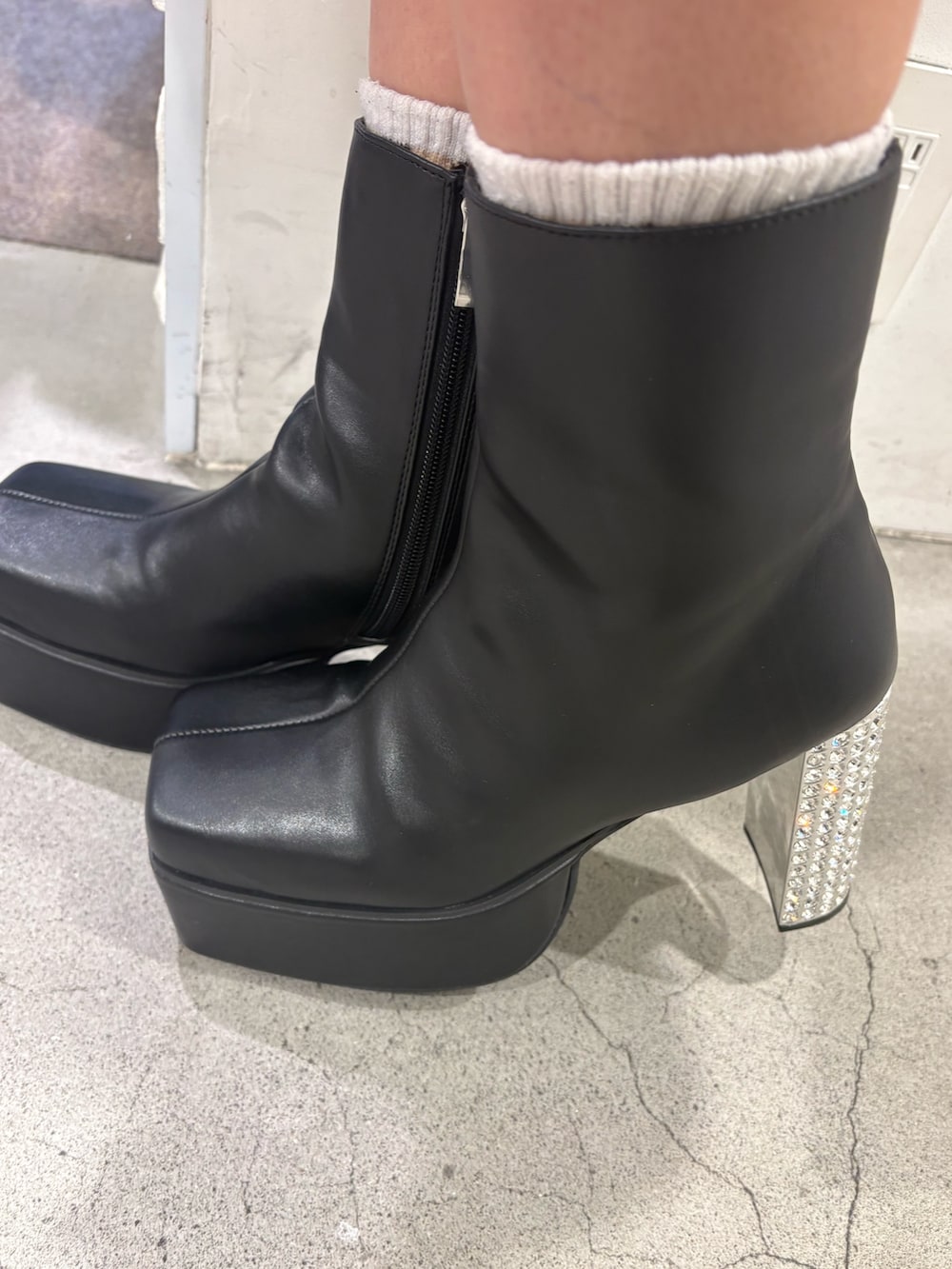 レッド系のニット/セーター、ブルー系のデニムパンツ、ブラック系のブーツを着用したレディースの冬コーディネートの6枚目の写真