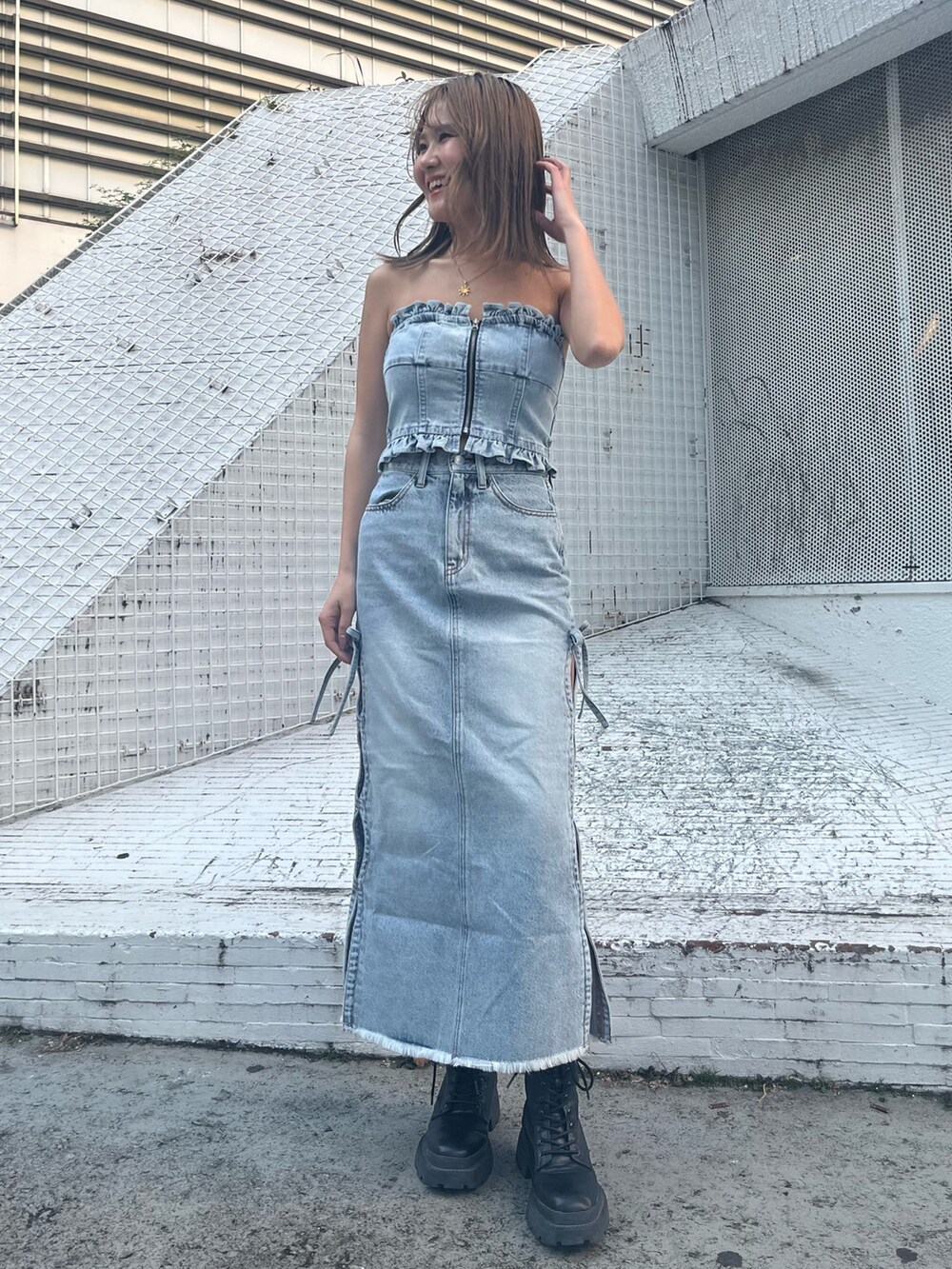 ブルー系のデニムジャケット、ブルー系のチューブトップ、ブルー系のデニムスカートを着用したレディースの冬コーディネートの2枚目の写真