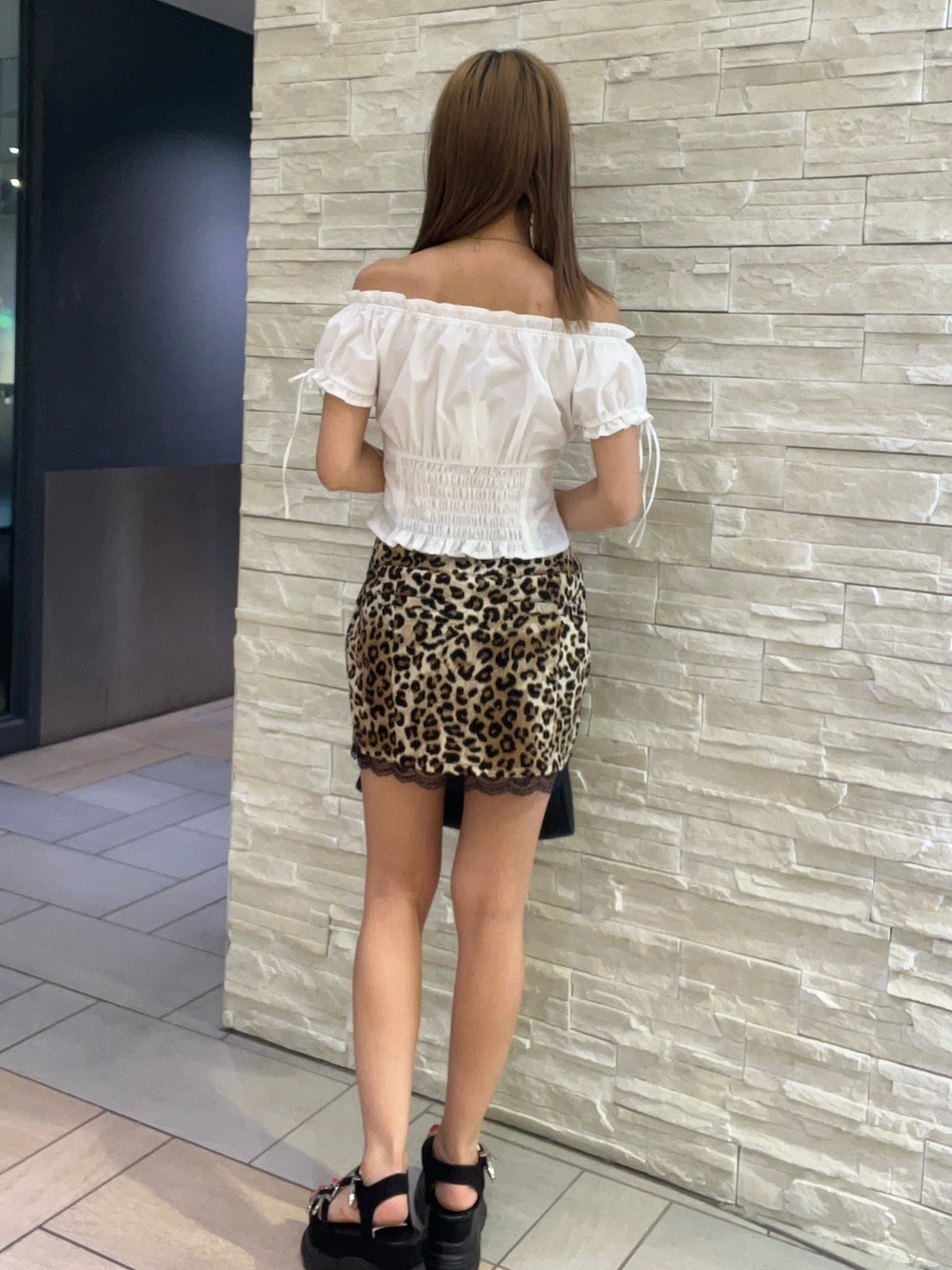 ホワイト系のシャツ/ブラウス、ベージュ系のスカート、ブラック系のサンダルを着用したレディースの夏コーディネートの3枚目の写真