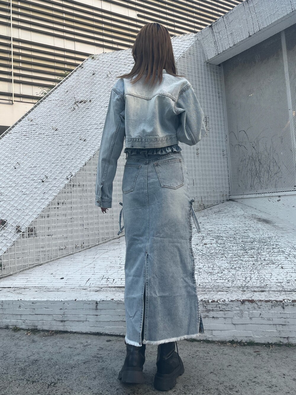 ブルー系のデニムジャケット、ブルー系のチューブトップ、ブルー系のデニムスカートを着用したレディースの冬コーディネートの5枚目の写真