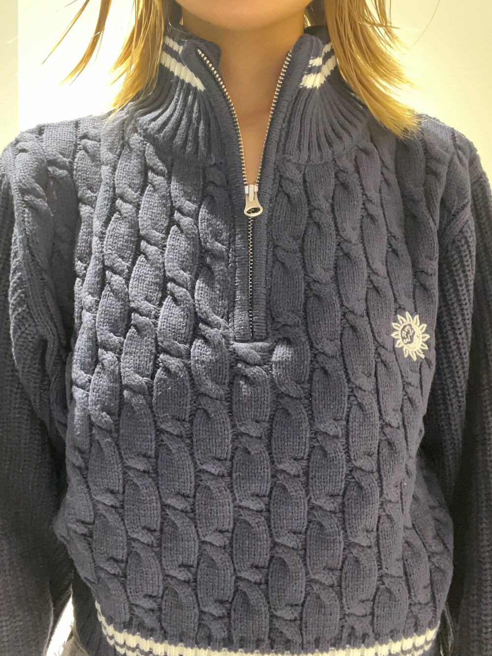 ブルー系のニット/セーター、ブラック系のショルダーバッグ、ブラック系のデニムパンツを着用したレディースの夏コーディネートの3枚目の写真