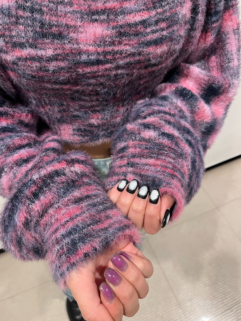 ピンク系のニット/セーター、シルバー系のボディバッグ/ウエストポーチ、ブルー系のデニムパンツを着用したレディースの冬コーディネートの5枚目の写真