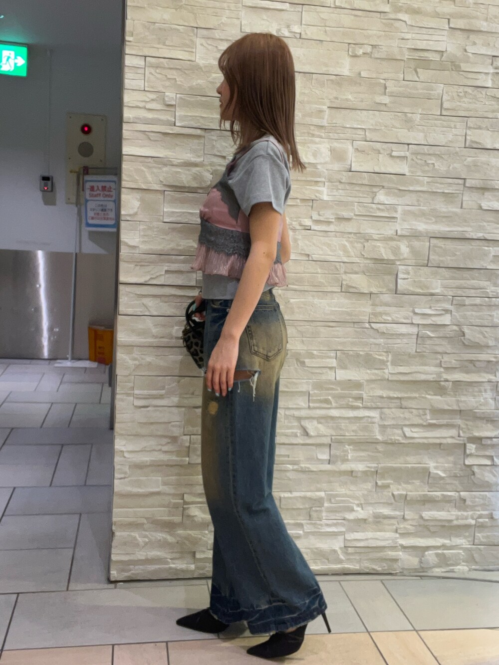 グレー系のTシャツ/カットソー、ピンク系のキャミソール、ブルー系のデニムパンツを着用したレディースの春コーディネートの2枚目の写真