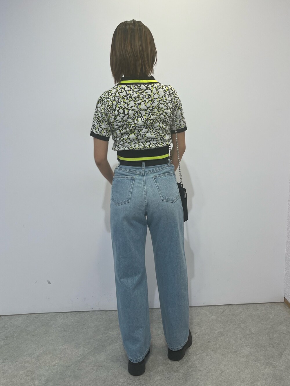 ブラック系のニット/セーター、ブルー系のデニムパンツを着用したレディースの春コーディネートの3枚目の写真