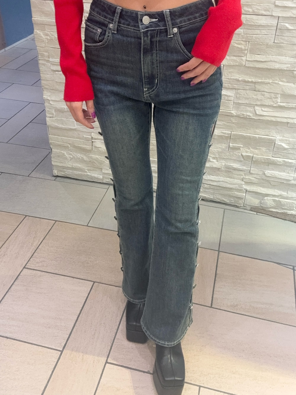 レッド系のニット/セーター、ブルー系のデニムパンツ、ブラック系のブーツを着用したレディースの冬コーディネートの5枚目の写真