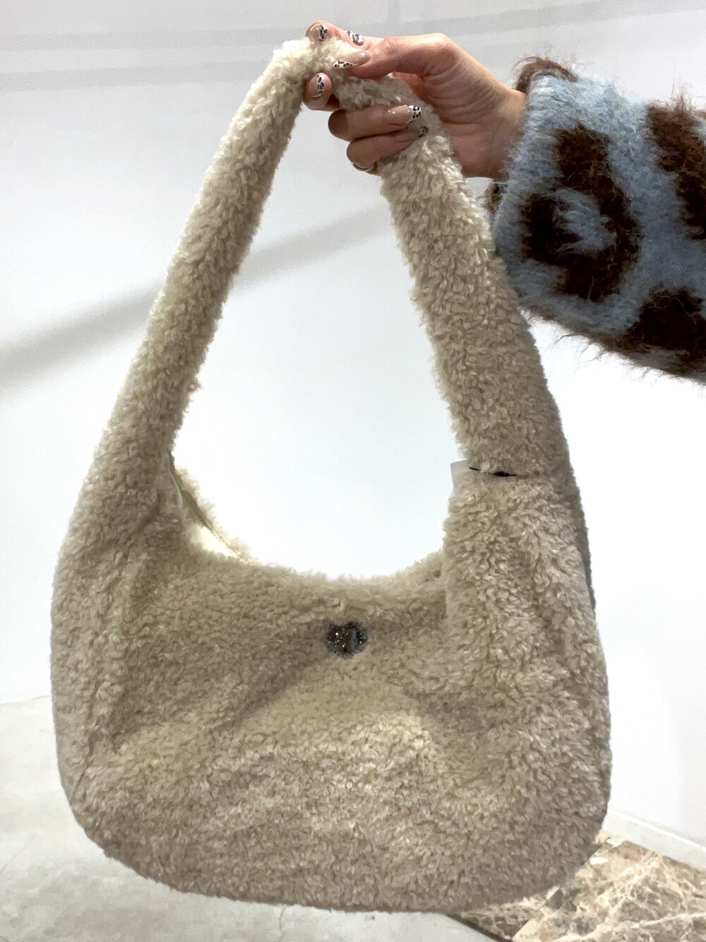 ブルー系のニット/セーター、ホワイト系のショルダーバッグ、ホワイト系のブーツを着用したレディースの秋コーディネートの5枚目の写真