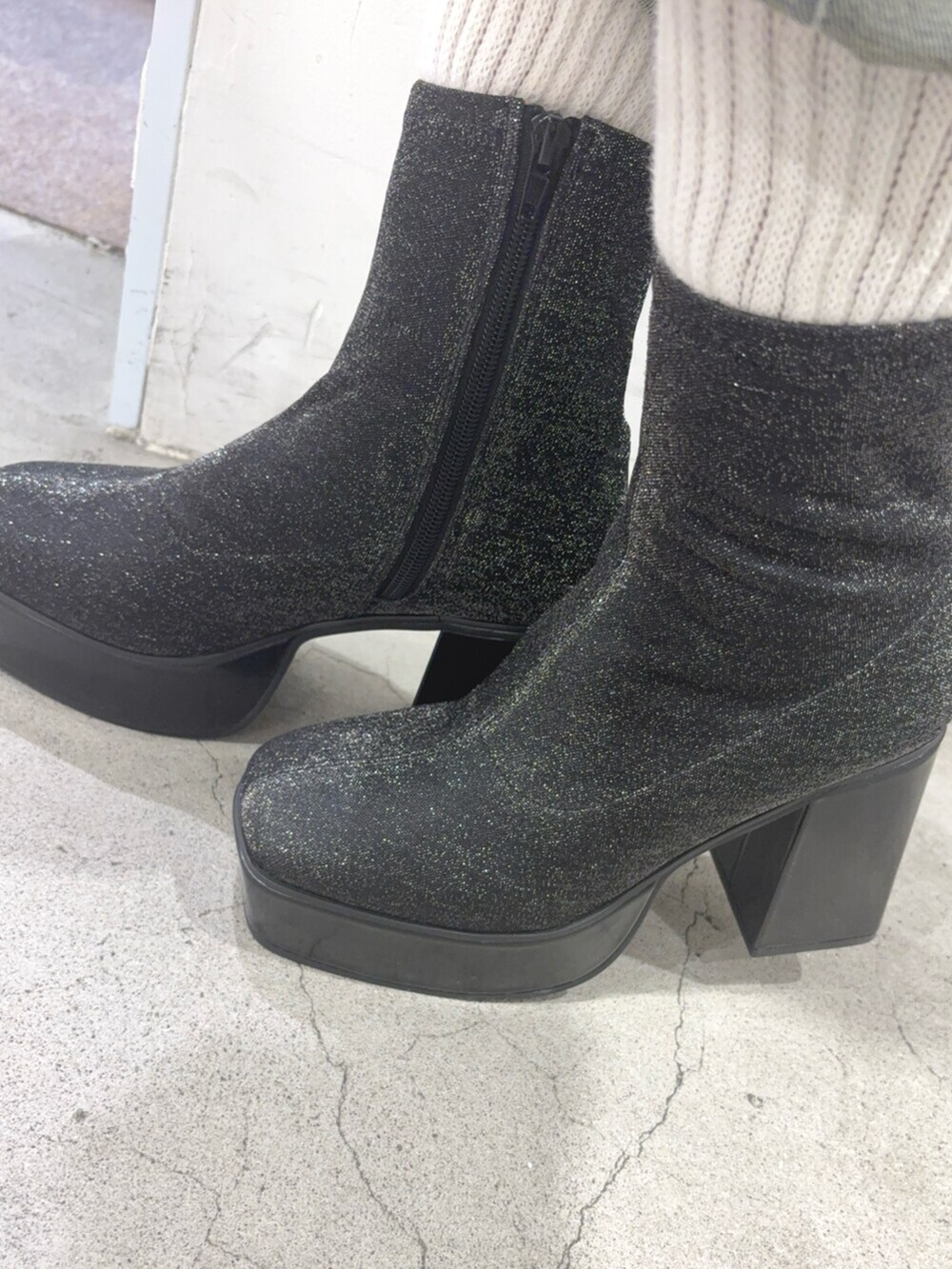 レッド系のニット/セーター、ブルー系のデニムパンツ、その他のブーツを着用したレディースの秋コーディネートの6枚目の写真