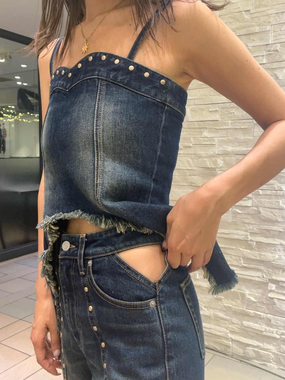 ブルー系のキャミソール、ブルー系のデニムパンツ、ベージュ系のサンダルを着用したレディースの夏コーディネートの6枚目の写真