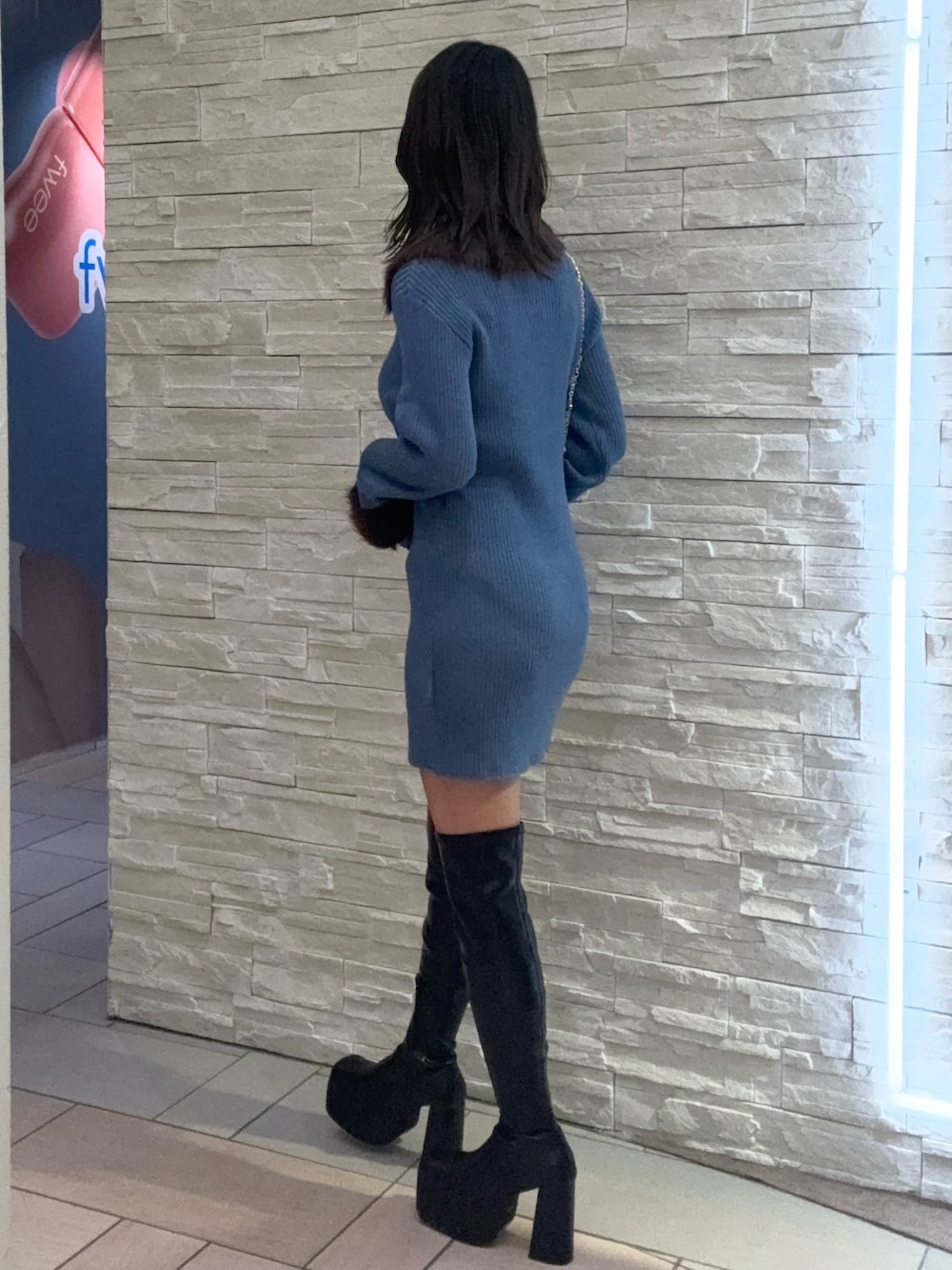 ブルー系のワンピース、ブラック系のショルダーバッグ、ブラック系のブーツを着用したレディースの冬コーディネートの2枚目の写真