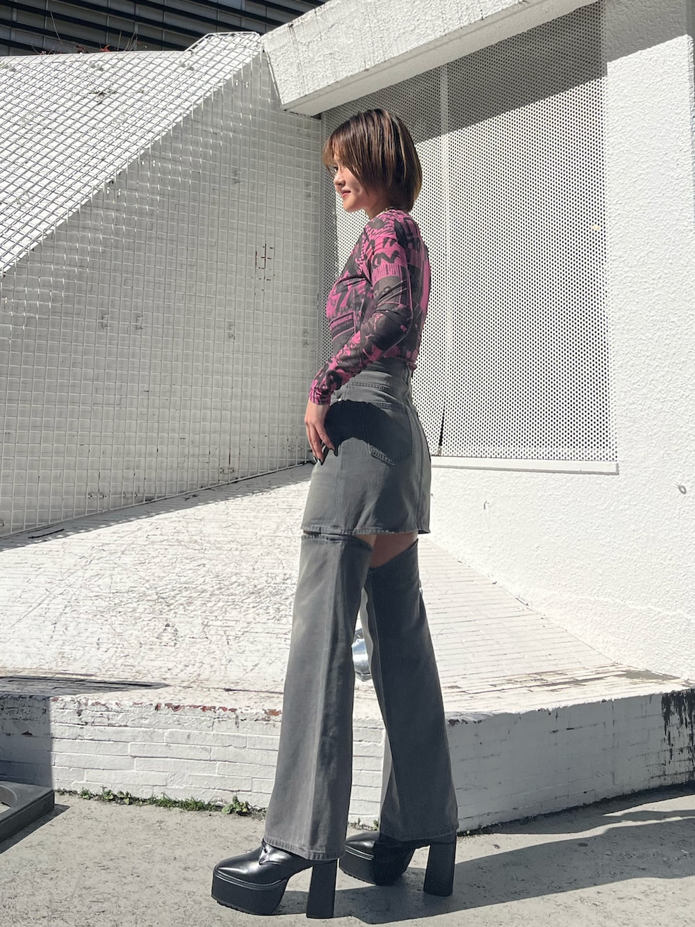 ピンク系のTシャツ/カットソー、ブラック系のデニムパンツ、ブラック系のブーツを着用したレディースの冬コーディネートの2枚目の写真