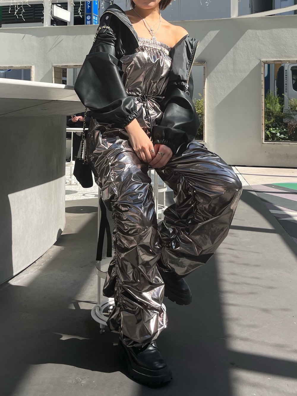 シルバー系のつなぎ/オールインワン、ブラック系のブーツ、ブラック系のサングラスを着用したレディースの冬コーディネートの2枚目の写真