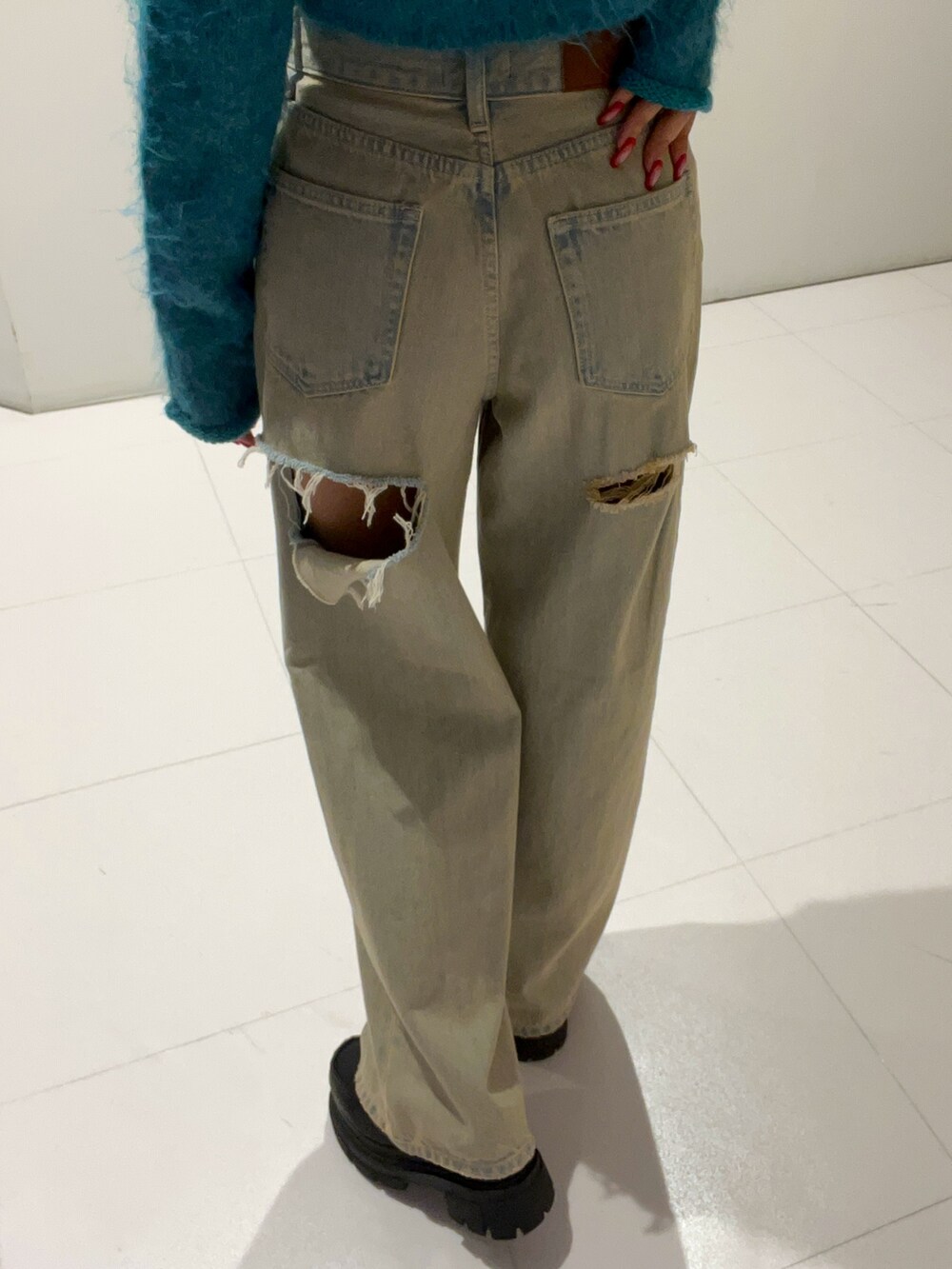 ブルー系のニット/セーター、ブルー系のデニムパンツ、ブラック系のローファーを着用したレディースの秋コーディネートの6枚目の写真