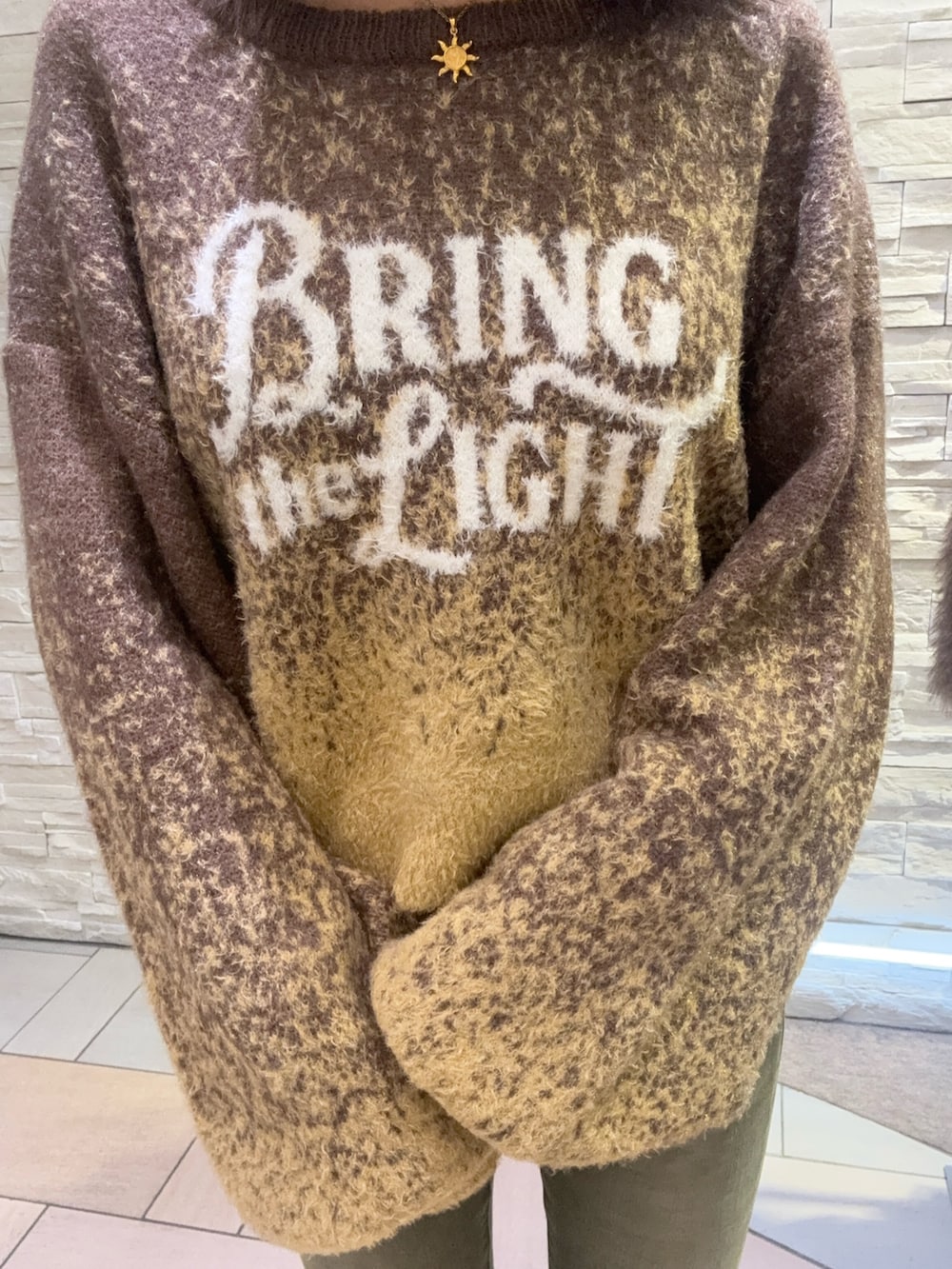 その他のブーツ、ブラウン系のニット/セーター、グリーン系のデニムパンツを着用したレディースの冬コーディネートの4枚目の写真