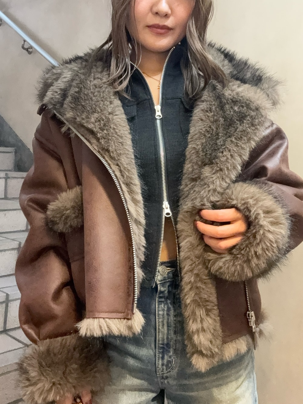 ブラウン系のブルゾン、ブラック系のTシャツ/カットソー、ブルー系のデニムパンツを着用したレディースの秋コーディネートの5枚目の写真