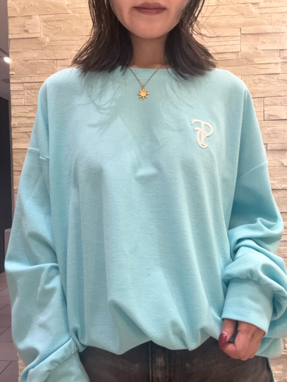 ブルー系のTシャツ/カットソー、ブラック系のデニムスカート、ブラウン系のブーツを着用したレディースの秋コーディネートの4枚目の写真