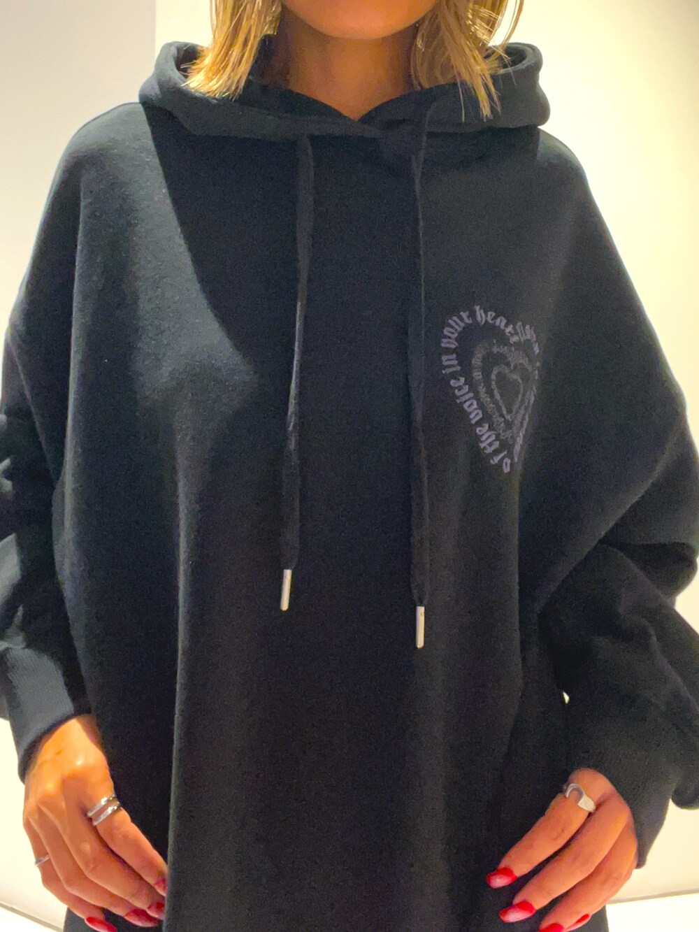 ブラック系のパーカー、ブルー系のハンドバッグ、ホワイト系のその他パンツを着用したレディースの秋コーディネートの4枚目の写真