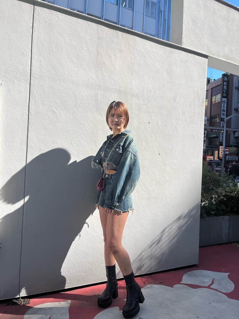 ブルー系のデニムジャケット、ブルー系のデニムパンツ、ピンク系のショルダーバッグを着用したレディースの冬コーディネートの2枚目の写真