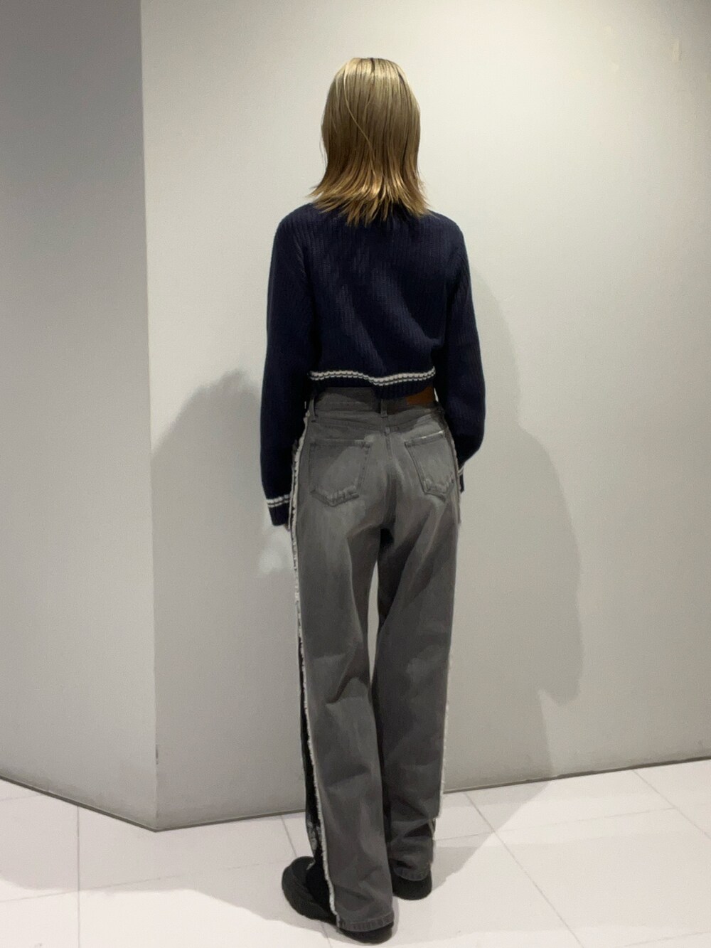 ブルー系のニット/セーター、ブラック系のショルダーバッグ、ブラック系のデニムパンツを着用したレディースの夏コーディネートの5枚目の写真