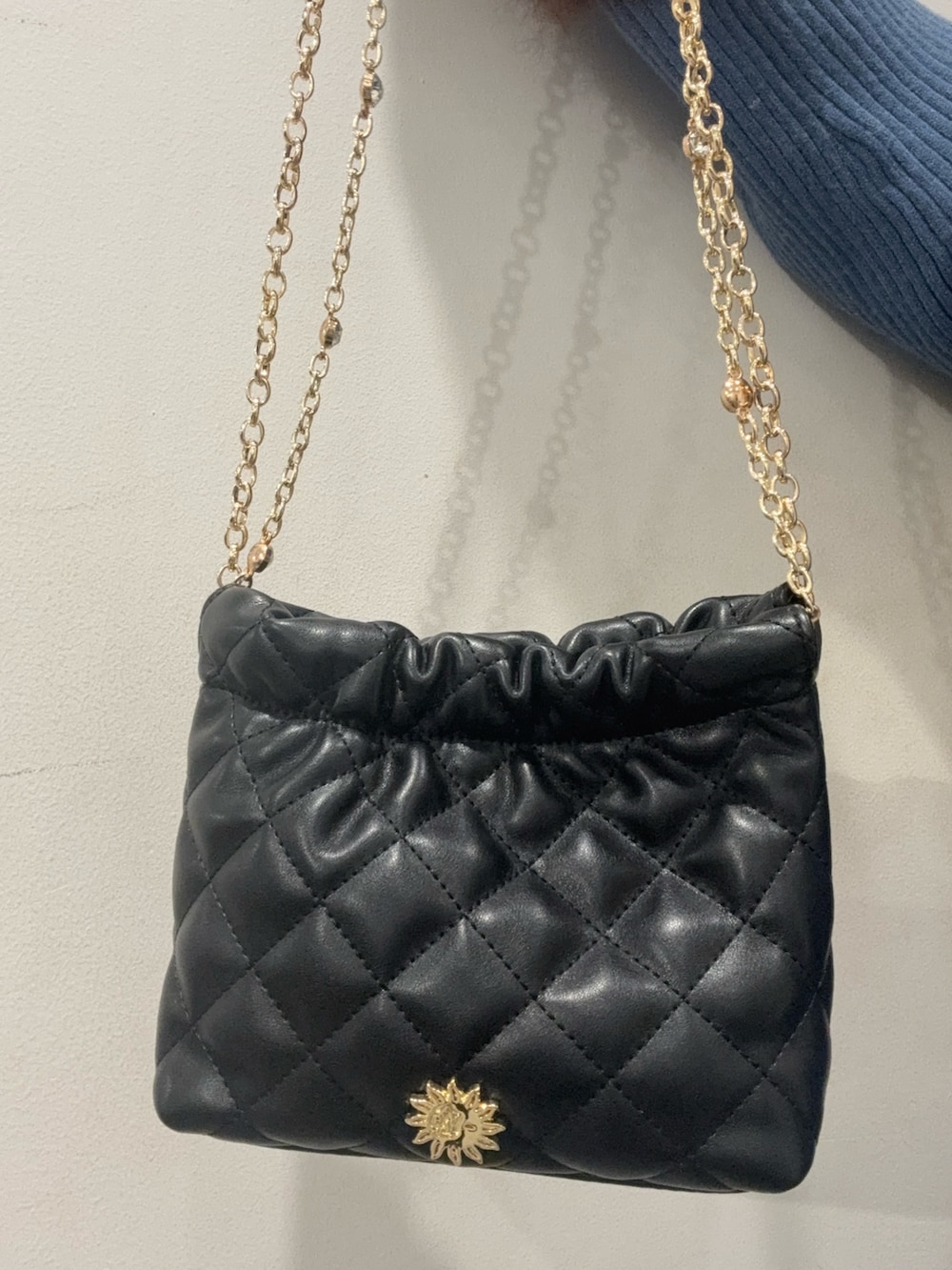 ブルー系のワンピース、ブラック系のショルダーバッグ、ブラック系のブーツを着用したレディースの冬コーディネートの5枚目の写真