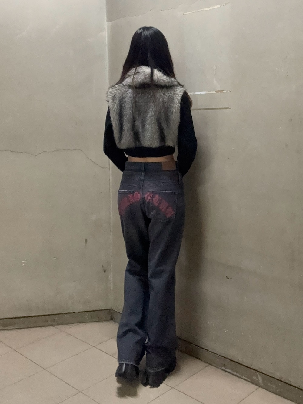 ブラック系のブルゾン、ブラック系のデニムパンツ、ブラック系のブーツを着用したレディースの秋コーディネートの3枚目の写真