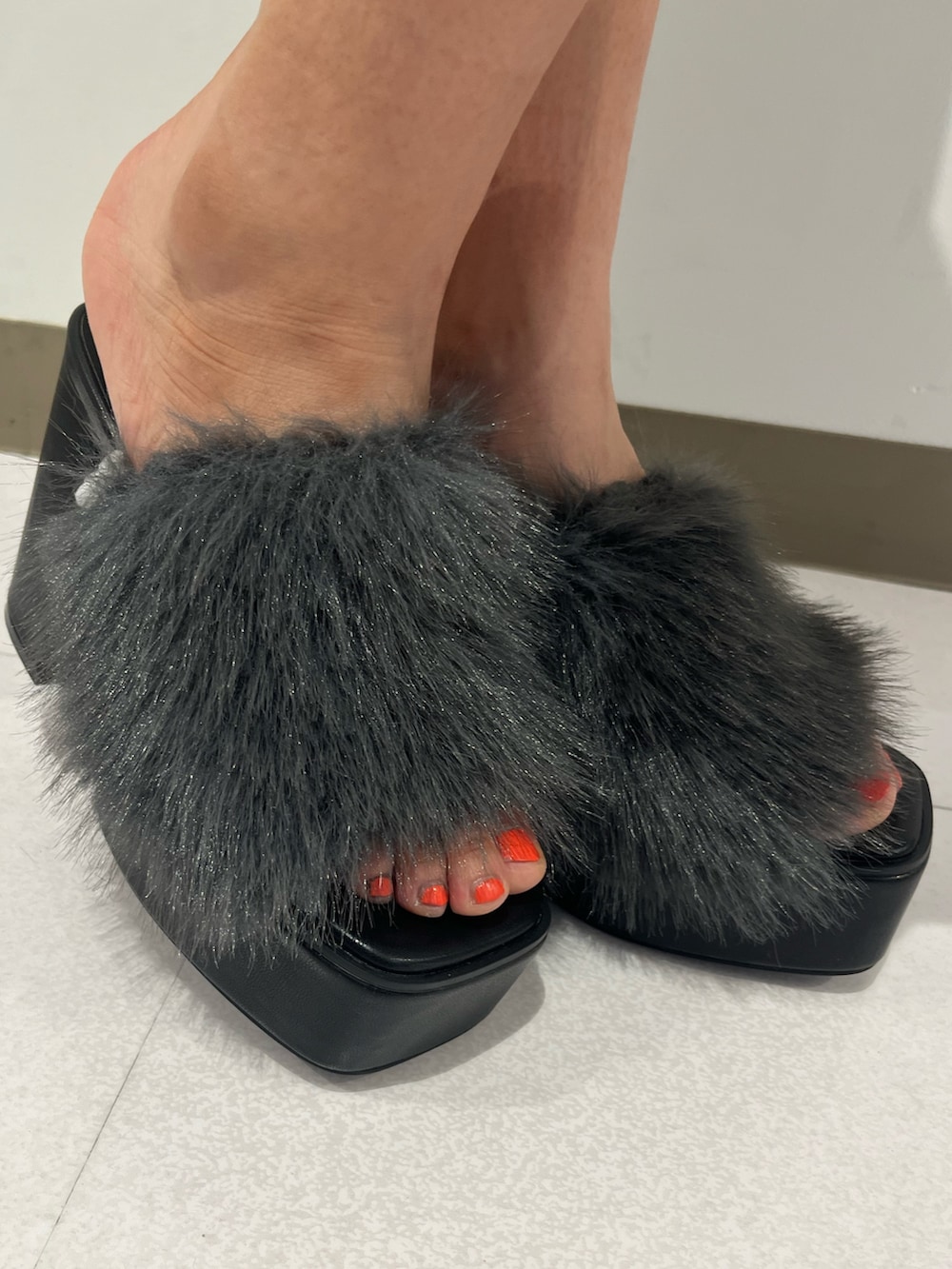 レッド系のタンクトップ、ブラック系のデニムパンツ、ブラック系のサンダルを着用したレディースの夏コーディネートの7枚目の写真