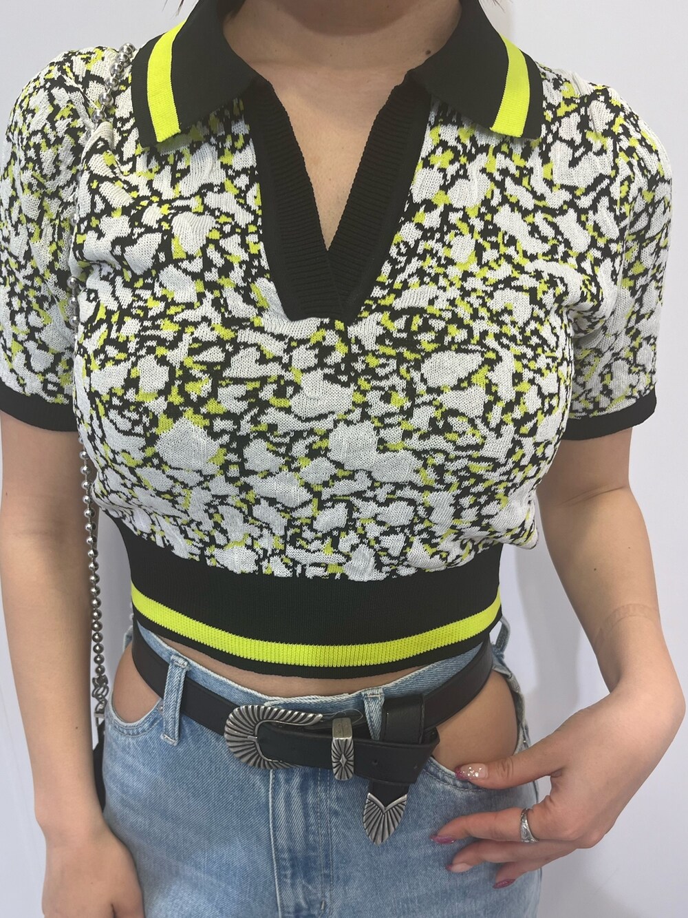 ブラック系のニット/セーター、ブルー系のデニムパンツを着用したレディースの春コーディネートの5枚目の写真