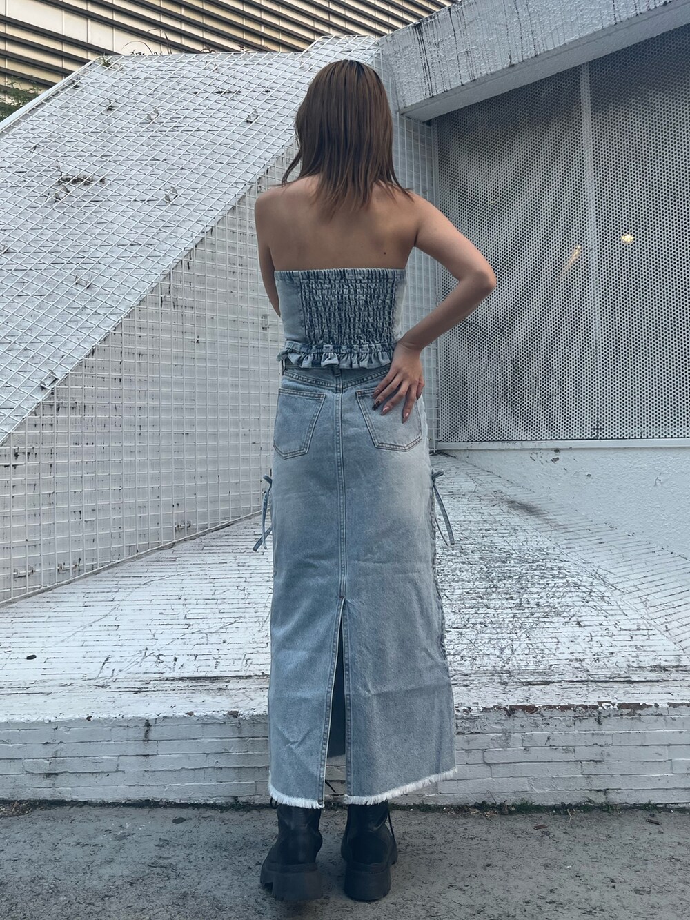 ブルー系のデニムジャケット、ブルー系のチューブトップ、ブルー系のデニムスカートを着用したレディースの冬コーディネートの6枚目の写真