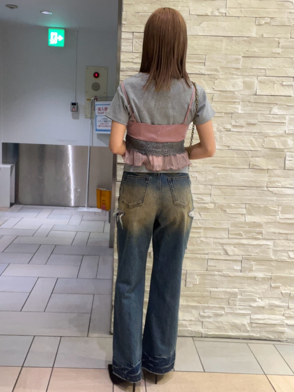 グレー系のTシャツ/カットソー、ピンク系のキャミソール、ブルー系のデニムパンツを着用したレディースの春コーディネートの3枚目の写真