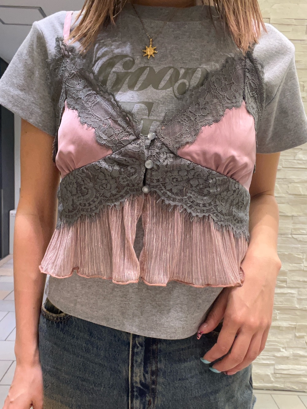 グレー系のTシャツ/カットソー、ピンク系のキャミソール、ブルー系のデニムパンツを着用したレディースの春コーディネートの4枚目の写真