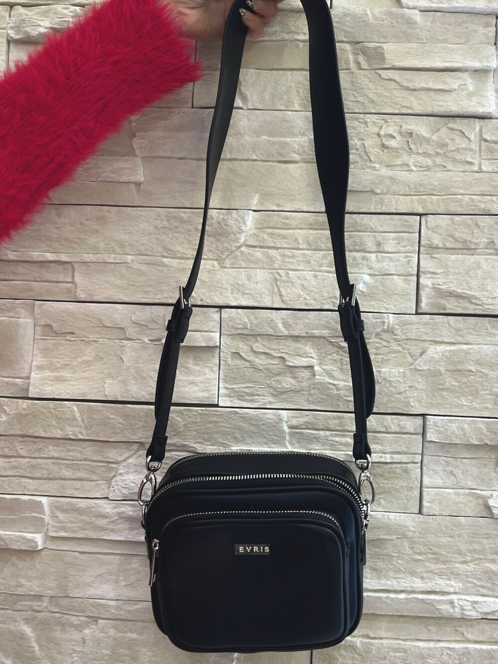 ピンク系のニット/セーター、ブルー系のデニムパンツ、ブラック系のショルダーバッグを着用したレディースの秋コーディネートの7枚目の写真