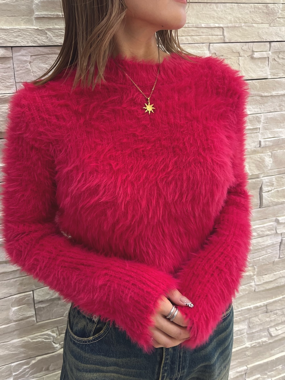 ピンク系のニット/セーター、ブルー系のデニムパンツ、ブラック系のショルダーバッグを着用したレディースの秋コーディネートの4枚目の写真