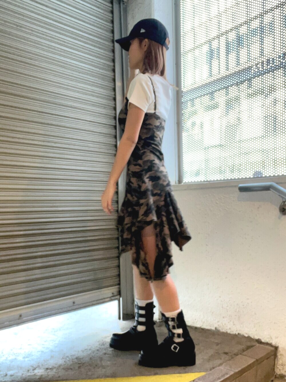 ホワイト系のTシャツ/カットソー、グリーン系のワンピース、ブラック系のブーツを着用したレディースの春コーディネートの2枚目の写真