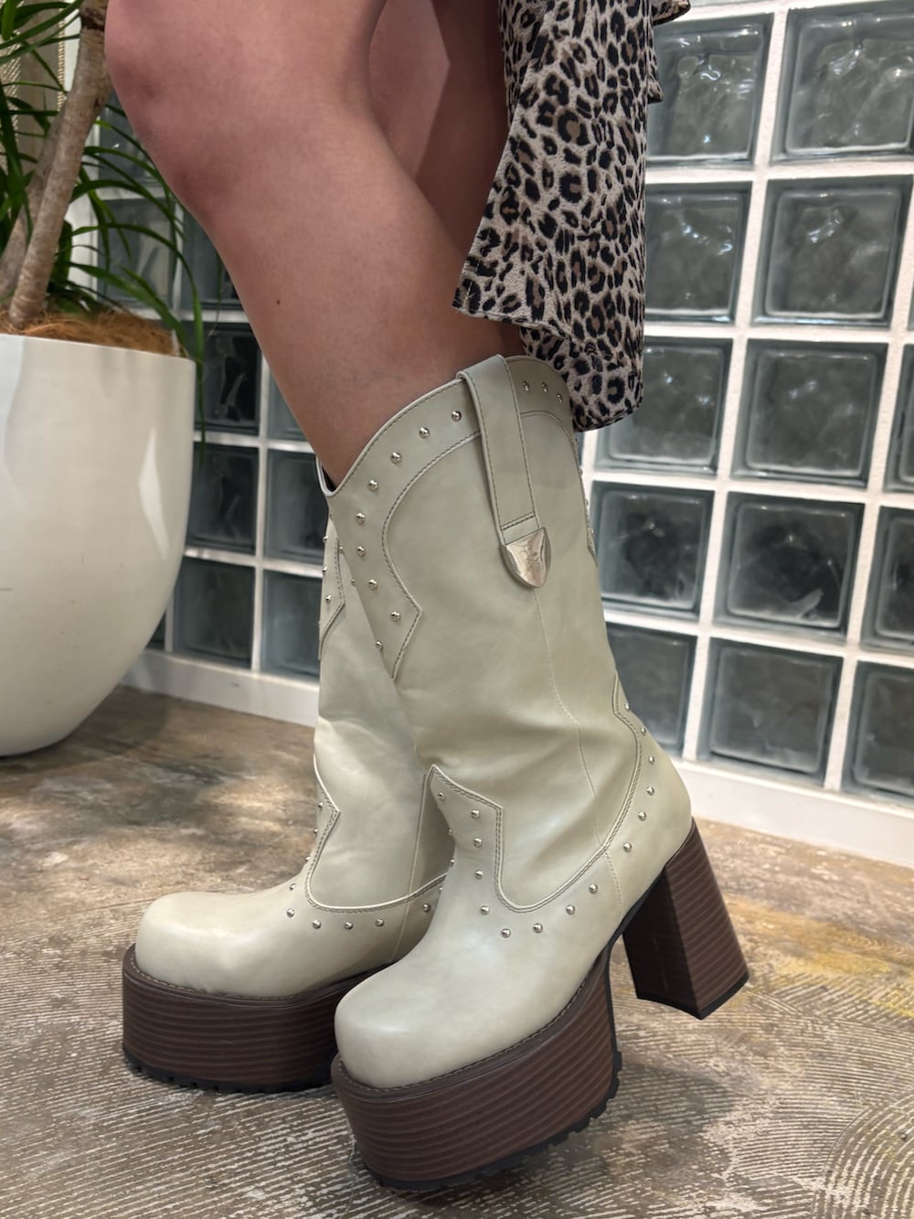 ベージュ系のワンピース、ホワイト系のブーツを着用したレディースの春コーディネートの5枚目の写真