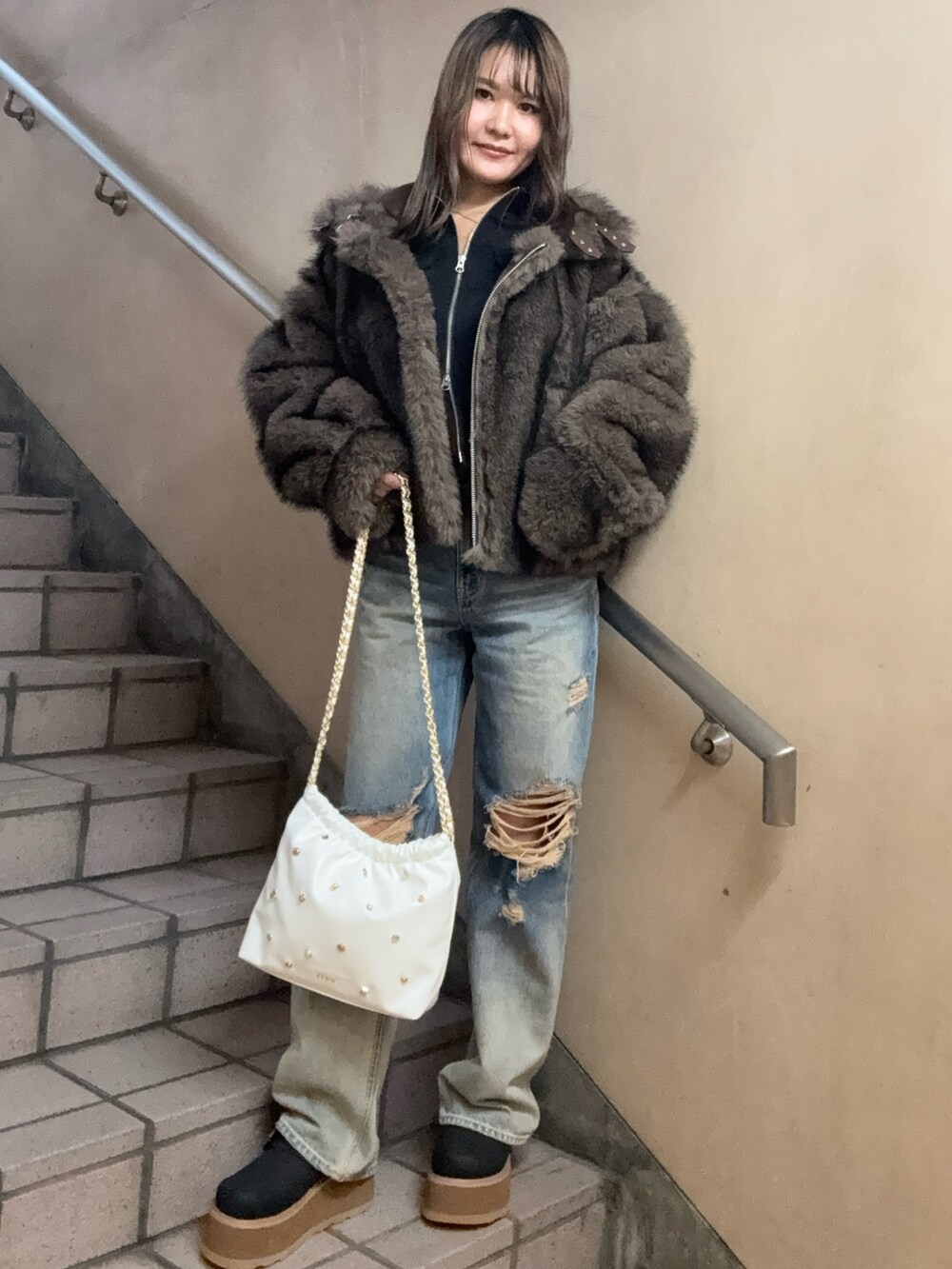 ブラウン系のブルゾン、ブラック系のTシャツ/カットソー、ブルー系のデニムパンツを着用したレディースの秋コーディネートの2枚目の写真