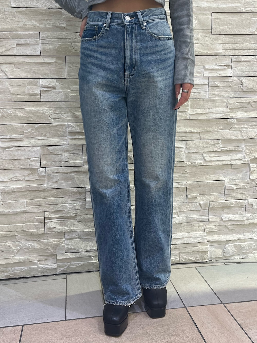 ピンク系のスタジャン、グレー系のTシャツ/カットソー、ブルー系のデニムパンツを着用したレディースの冬コーディネートの6枚目の写真