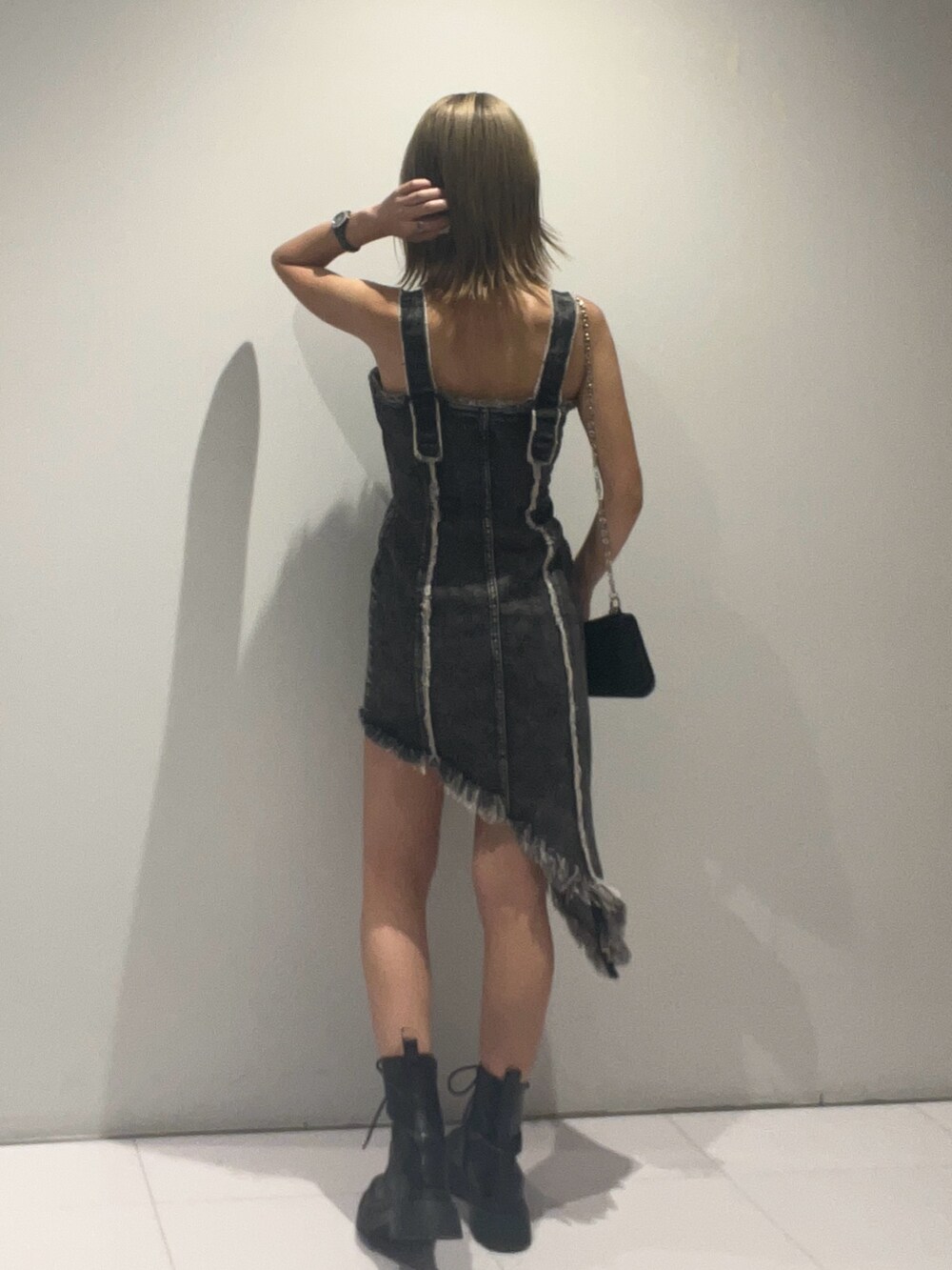 ブラック系のワンピース、ブラック系のショルダーバッグ、ブラック系のブーツを着用したレディースの夏コーディネートの3枚目の写真