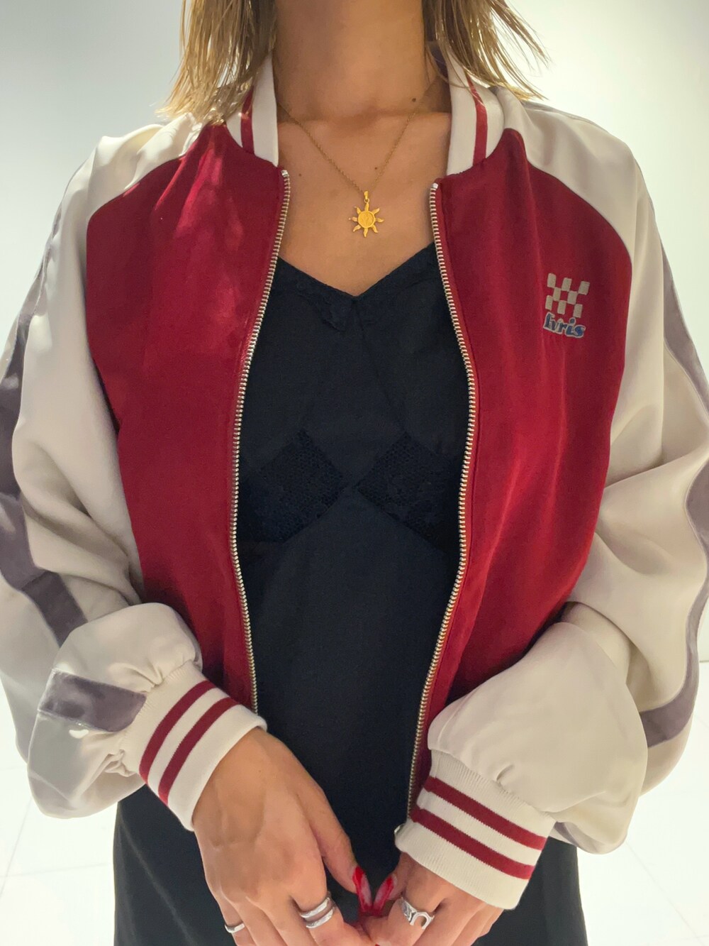 レッド系のブルゾン、ブラック系のワンピース、ブラック系のショルダーバッグを着用したレディースの秋コーディネートの5枚目の写真