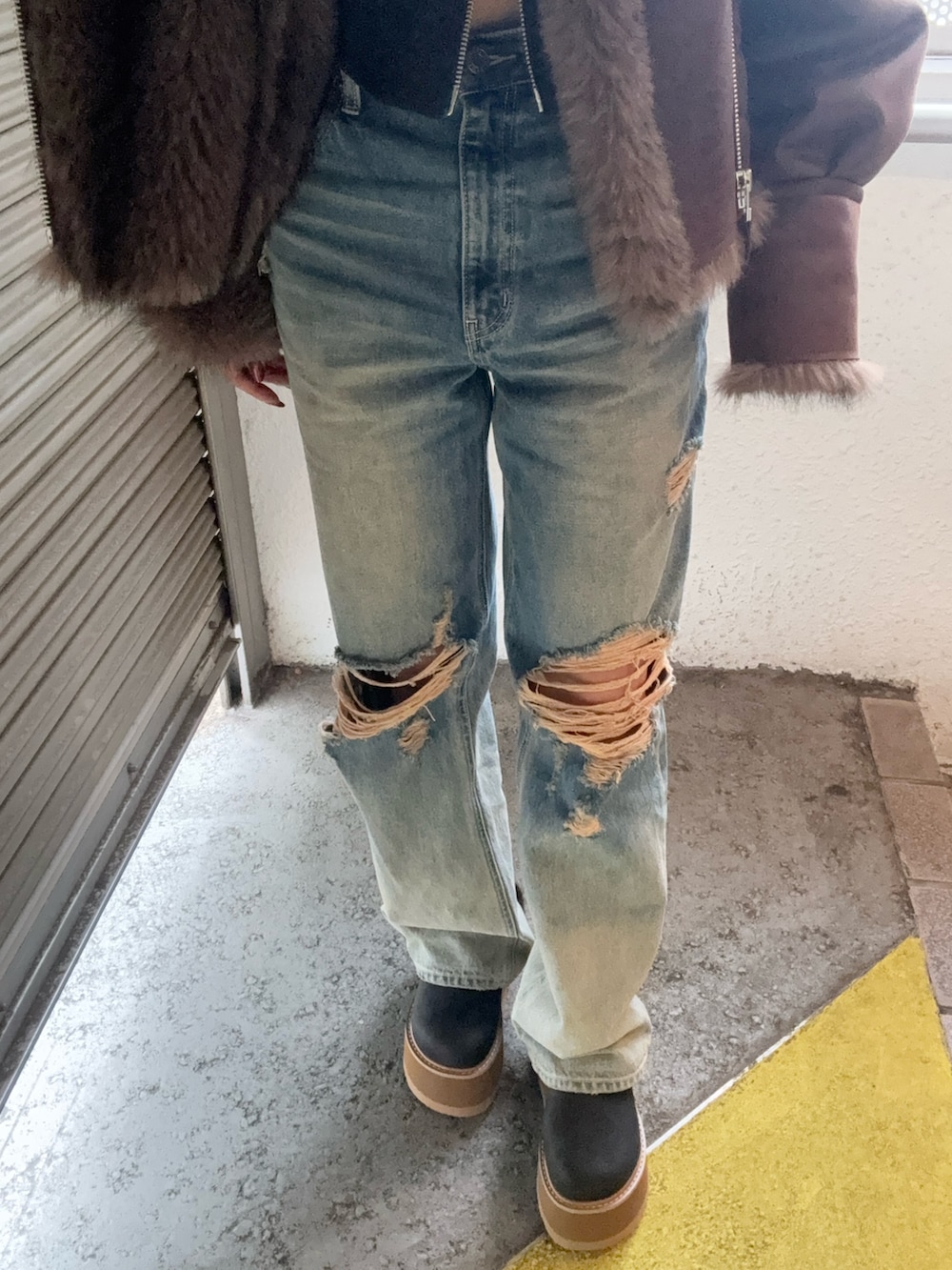 ブラウン系のブルゾン、ブラック系のTシャツ/カットソー、ブルー系のデニムパンツを着用したレディースの秋コーディネートの9枚目の写真