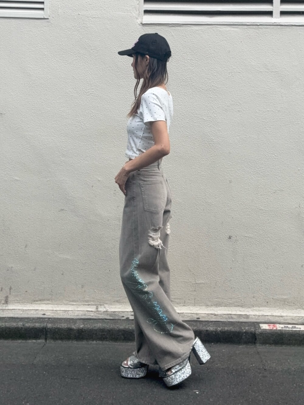 シルバー系のサンダル、ホワイト系のTシャツ/カットソー、ベージュ系のデニムパンツを着用したレディースの夏コーディネートの2枚目の写真