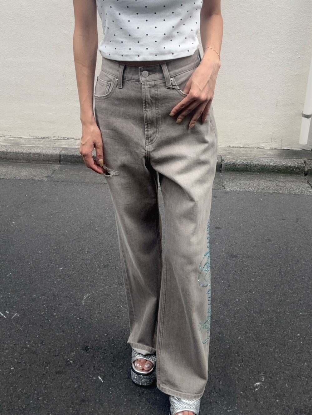 シルバー系のサンダル、ホワイト系のTシャツ/カットソー、ベージュ系のデニムパンツを着用したレディースの夏コーディネートの5枚目の写真