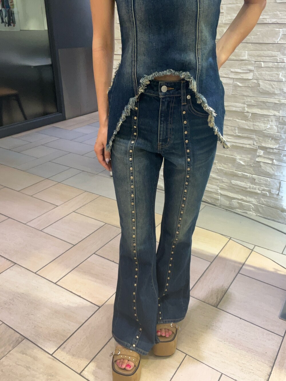 ブルー系のキャミソール、ブルー系のデニムパンツ、ベージュ系のサンダルを着用したレディースの夏コーディネートの5枚目の写真