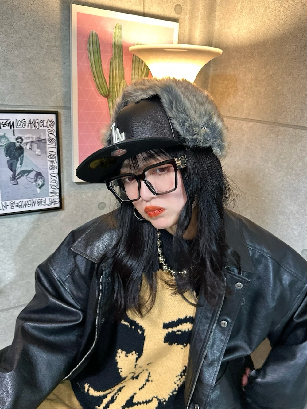 ブラック系のニット/セーター、ブラック系のブルゾン、ブラウン系のデニムパンツを着用したレディースの冬コーディネートの2枚目の写真