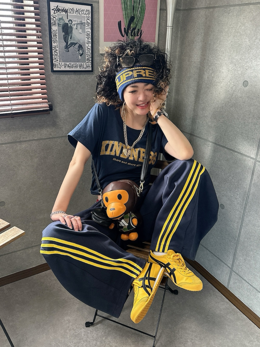 ブラウン系のショルダーバッグ、ブルー系のパンツ、イエロー系のスニーカーを着用したレディースの秋コーディネートの4枚目の写真