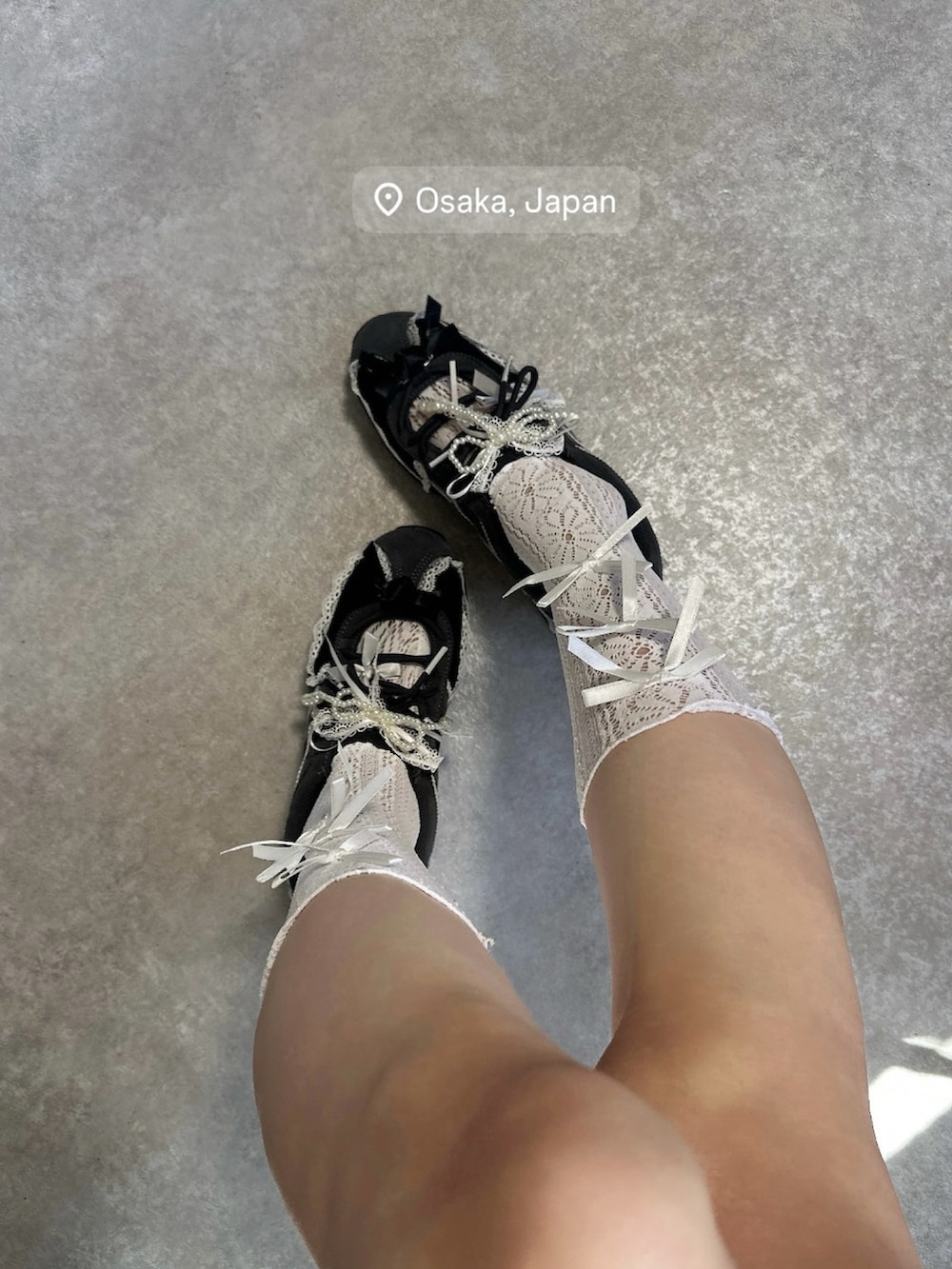グレー系のスニーカー、ブラック系のハンドバッグを着用したレディースの秋コーディネートの2枚目の写真