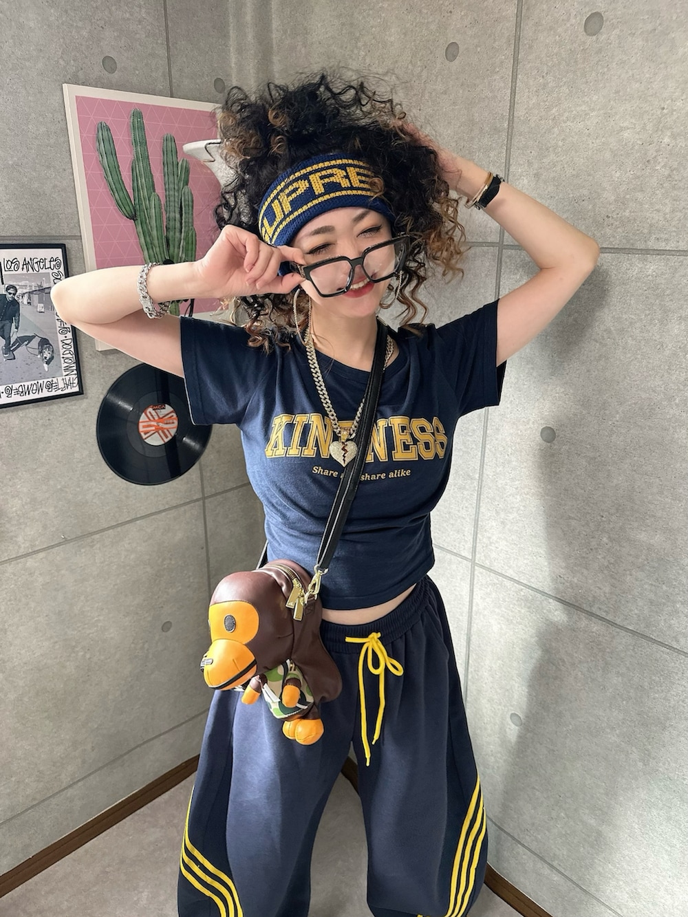 ブラウン系のショルダーバッグ、ブルー系のパンツ、イエロー系のスニーカーを着用したレディースの秋コーディネートの2枚目の写真