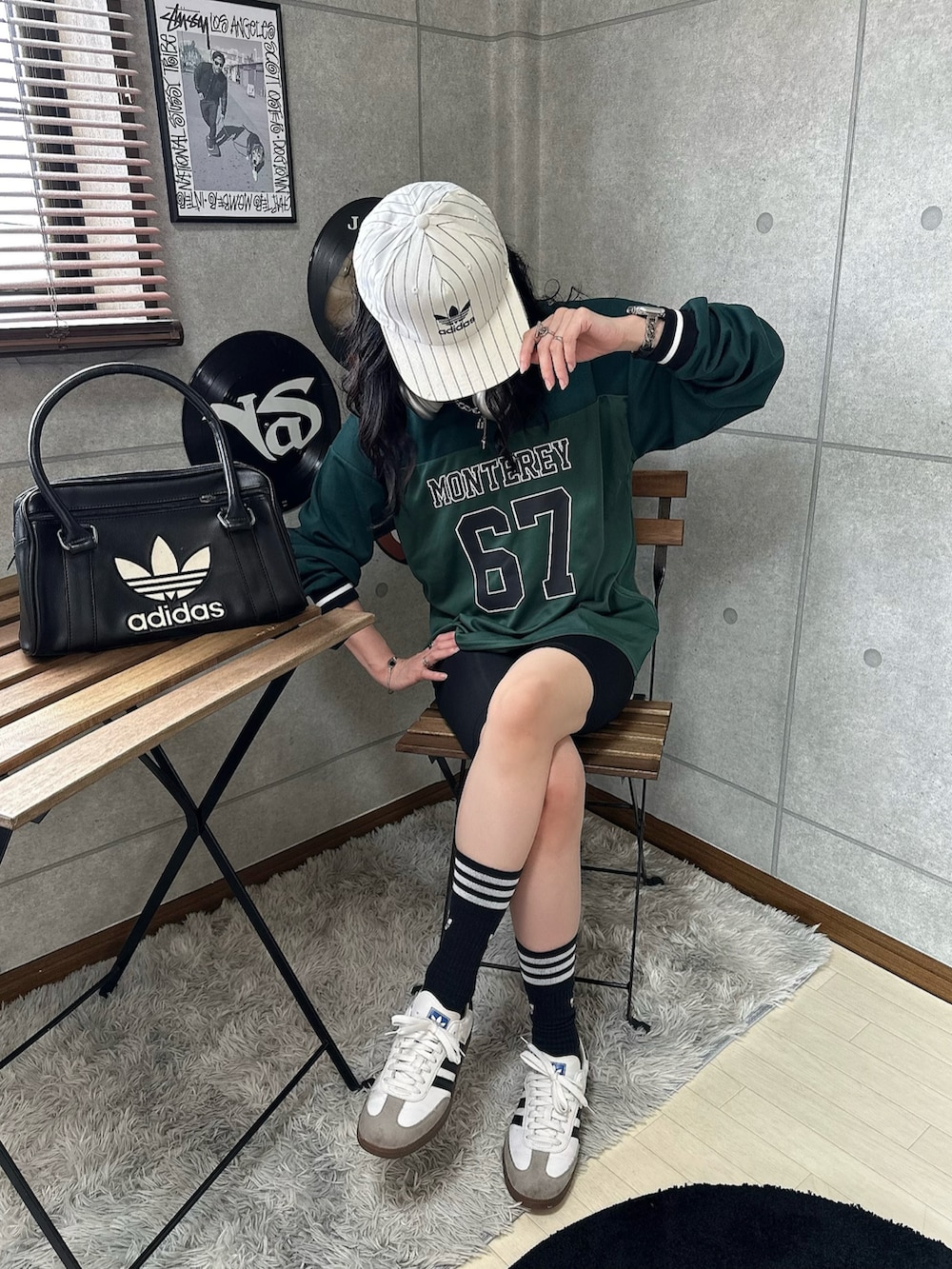 グリーン系のジャージ、ホワイト系のスニーカー、ブラック系のハンドバッグを着用したレディースの秋コーディネートの2枚目の写真